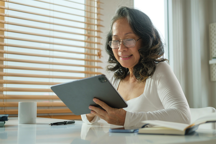 A senior looks at a tablet computer