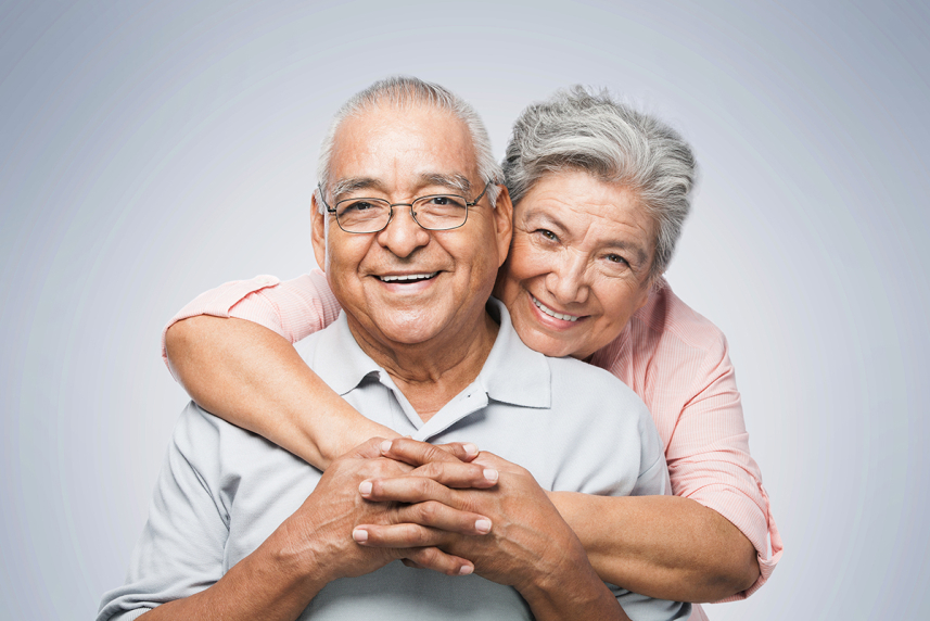 A woman hugging a man from behind.