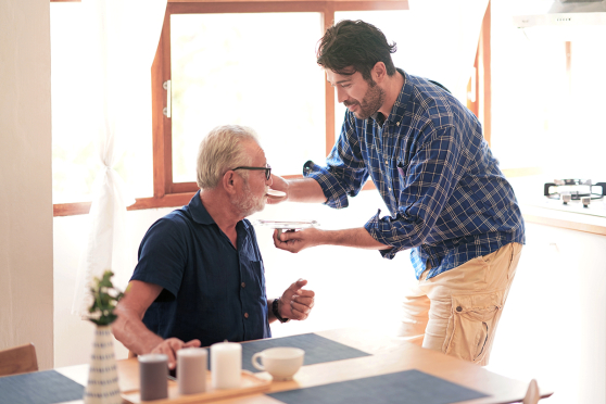 A man giving an older man medicine