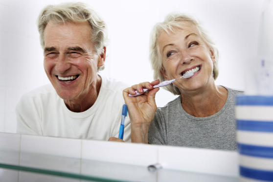 A couple brushing their teeth.