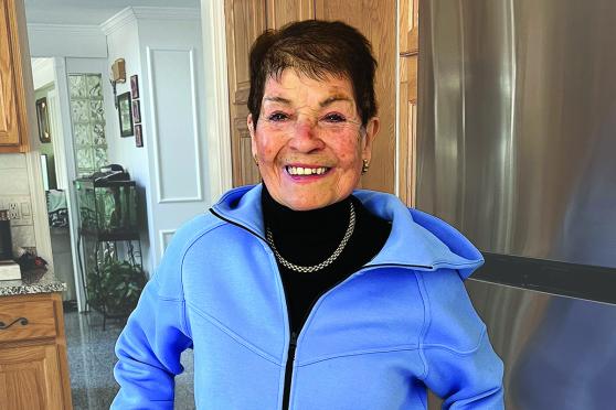 A woman smiling with her hands on her hips.