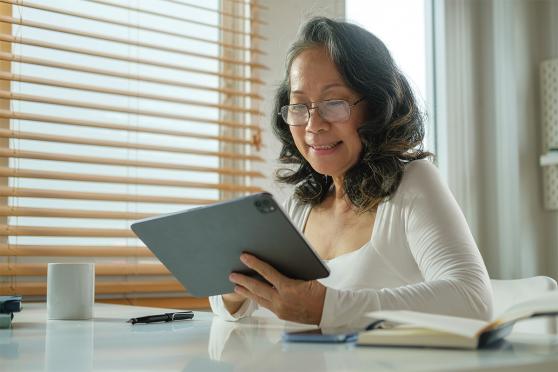A senior looks at a tablet computer
