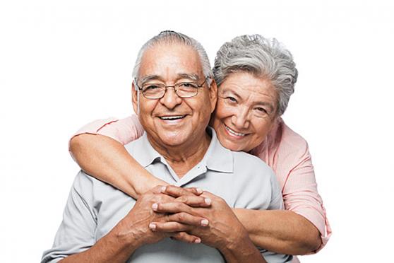 A woman hugging a man from behind.